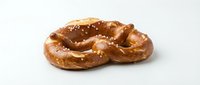 Freshly baked pretzel with coarse salt crystals on white background, isolated for bakery, food packaging, menu design and culinary projects.