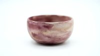 Handmade ceramic bowl with rustic mauve and cream glazed finish, isolated on white background, suitable for home decor, tableware design, and product mockups.