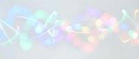 Soft pastel bokeh lights with flowing ribbons and blurred orbs in pink, blue, green, and yellow tones create an ethereal, dreamy atmosphere suitable for backgrounds, overlays, and festive designs.
