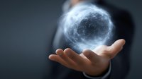 Glowing blue energy sphere floating above businessman hand against dark background, representing power, innovation and future technology concepts.