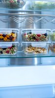 Organized meal prep containers with fresh vegetables, grains, and proteins stored in refrigerator for weekly food planning and healthy eating routines.