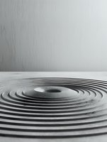 Zen garden with concentric circles raked in sand against minimalist white background, creating peaceful meditation atmosphere.