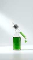Green serum dropper bottle with falling drop on light background, skincare cosmetic product for beauty and wellness advertising.