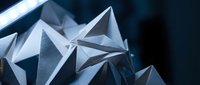 Abstract geometric crystal formations with sharp angular facets reflecting light in metallic blue tones for modern design backgrounds.