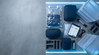 Modern business travel essentials organized in open suitcase with laptop, tablet, headphones and accessories for professional trips.