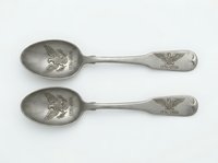 Pair of vintage silver spoons with ornate handles and decorative bowl featuring classical profile relief, isolated on white background for design and product use.