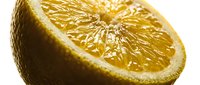 Fresh halved lemon with juicy pulp and textured peel, close-up macro shot on white background, showcasing vibrant citrus detail.