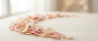 Delicate rose petals scattered on white surface creating romantic atmosphere for wedding ceremonies, spa treatments, and luxury beauty product photography.