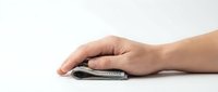 Hand resting on wireless computer mouse against white background, isolated for web design, marketing materials, and technology presentations.