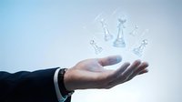 Businessman hand presenting floating chess pieces symbolizing strategic planning and leadership concepts for corporate presentations.