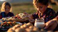 Young girl in floral dress at rustic outdoor dinner table with fresh baked bread, seasonal harvest vegetables and warm evening sunlight creating cozy autumn atmosphere.