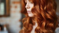 Young redhead woman with curly auburn hair in soft natural light, profile view showing healthy shiny waves for beauty and haircare concepts.