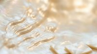Abstract golden water ripples with soft bokeh light effects creating dreamy flowing motion patterns for luxury spa wellness meditation backgrounds.