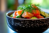 Fresh salmon salad with dill and vegetables served in elegant black bowl. Healthy gourmet meal with smoked fish, greens and colorful ingredients for restaurant menu.