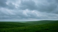 Rolling green hills under dramatic cloudy sky, suitable for landscape backgrounds, environmental themes, and nature-based design projects.