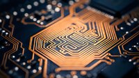 Close-up of a golden microchip on a dark circuit board with intricate copper pathways, showcasing advanced electronics and technology.