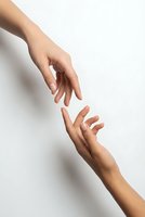 Two hands reaching toward each other in helping gesture on clean white background for teamwork and support concepts.