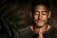 Peaceful middle-aged Hispanic man with closed eyes in prayer pose, hands together in meditation. Spiritual wellness and mindfulness concept for relaxation.