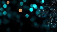 Magical winter evening atmosphere with turquoise and golden bokeh lights and pine branches creating festive holiday mood. Dark background with defocused spots.