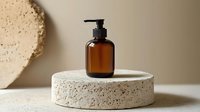 Minimalist amber glass pump bottle on round concrete podium against beige background. Modern cosmetic packaging for skincare and beauty products.