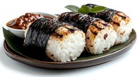 Grilled rice balls with nori seaweed wrapping served on ceramic plate with soy sauce, traditional Japanese onigiri cuisine for Asian food lovers.