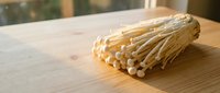 Fresh corn cob on wooden table with natural light, suitable for food photography, agriculture, and culinary design projects.