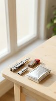 Everyday carry essentials on wooden desk featuring multi-tool, lighter, pen and clear case in bright natural lighting for modern lifestyle.