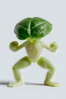 Creative food art featuring green bell pepper and sprouts arranged to form a playful humanoid figure standing on white background, isolated for design use.