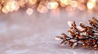 Festive pine cone with golden glitter on blurred bokeh background with warm lights creates magical holiday atmosphere. Great for seasonal designs.