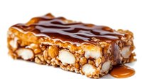 Chocolate caramel nut bar with almonds and peanuts drizzled with caramel sauce on white background isolated for confectionery and dessert designs.