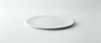 Empty white ceramic plate on clean white background isolated for kitchen dining and food presentation mockup design.
