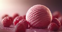 Creamy raspberry ice cream scoop surrounded by fresh ripe raspberries on pink background with soft focus and gentle lighting, creating appetizing dessert composition.