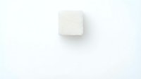 Single white sugar cube isolated on light background, ready for beverage, culinary, and food styling design projects.