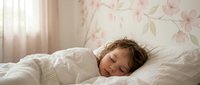 Peaceful young child sleeping comfortably in cozy bedroom with soft morning light and floral wall decor creating serene atmosphere for rest and dreams.
