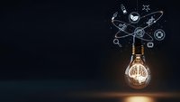 Glowing light bulb with digital innovation icons floating above on dark background representing creative ideas, technology solutions and business inspiration.