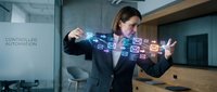 Woman in business attire interacting with holographic digital icons and data visualizations, representing controlled automation, technology integration, and smart business solutions.