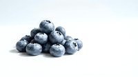 Fresh organic blueberries pile isolated on white background for healthy eating, cooking, baking and nutrition concepts.
