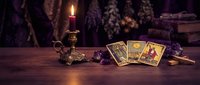 Mystical tarot cards spread on wooden table with burning candle in ornate holder, creating atmospheric fortune telling scene for spiritual guidance and divination.