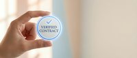 Hand holding circular verified contract badge symbol for business certification and legal document validation in professional office environment.