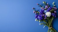 Fresh bouquet of purple and white flowers tied with twine against vibrant blue background, creating elegant contrast for greeting cards and floral designs.