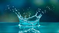 Crystal clear water splash with droplets frozen in motion against blue gradient background, suitable for beverage, wellness, and hydration marketing materials.