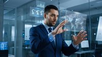 Professional businessman in navy suit interacting with futuristic holographic interface displaying global data analytics and charts in modern office.