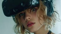 Young woman with curly blonde hair wearing virtual reality headset against light background, showcasing modern technology for gaming or simulation experience.