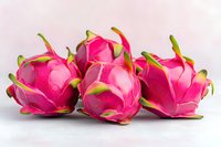 Fresh dragon fruit arranged on white background showing vibrant pink exterior and green scales, highlighting exotic tropical produce for food and health concepts.