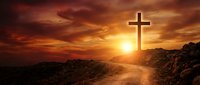 Christian cross silhouette against dramatic sunset sky over rocky desert landscape with golden sunlight rays creating spiritual atmosphere for faith concepts.
