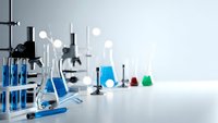 Modern laboratory workspace with scientific glassware, beakers, and research equipment on clean white surface for chemistry experiments and analysis.