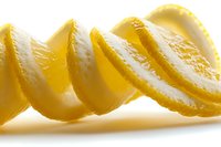 Fresh juicy lemon slices arranged in curved line on white background, bright yellow citrus fruit with textured pulp and peel, macro food photography.