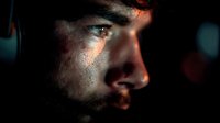 Dramatic side profile of young man with beard in low key lighting, sweat glistening on skin, intense expression against dark background.