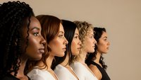 Diverse group of women in profile showing different ethnicities and hairstyles representing unity, teamwork and female empowerment in business setting.
