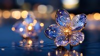 Crystal glass flower with golden center on reflective surface against blurred bokeh lights background creating magical atmosphere and sparkle effect.